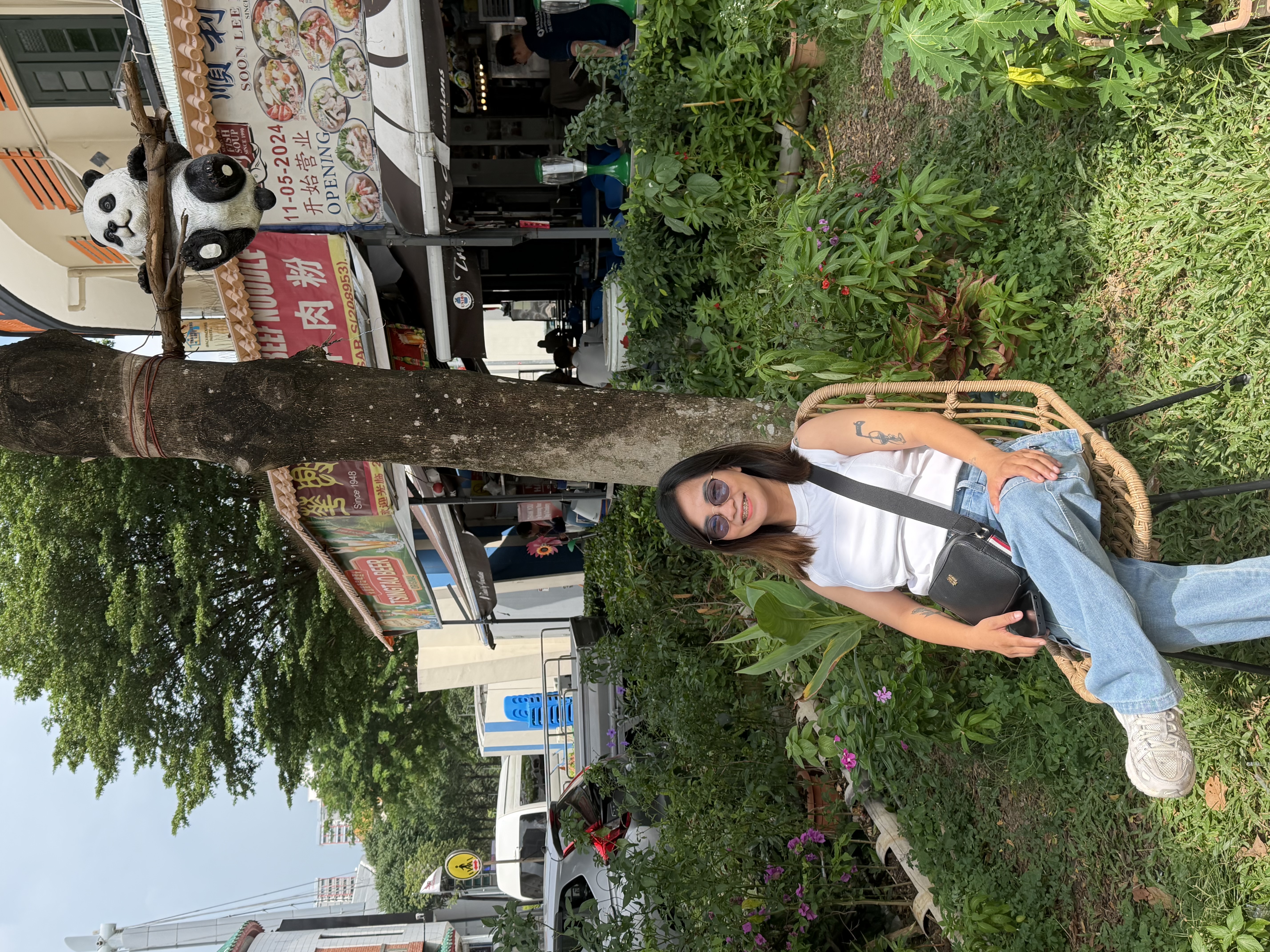 Eden Rollaiza Doldol seated in a garden beside a panda display
